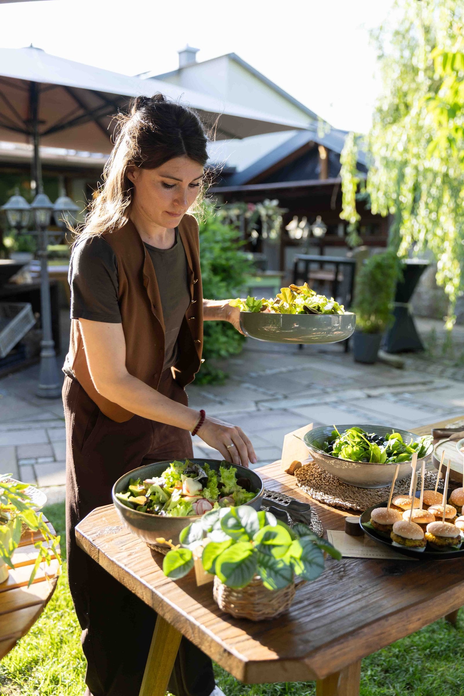Mitarbeiterin trägt frische Speisen zum Buffet